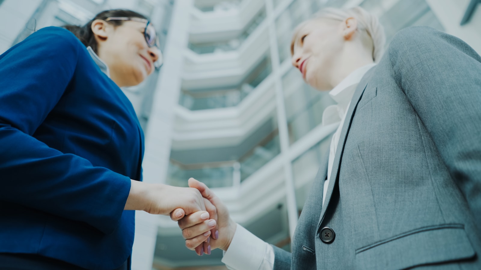 Two business professionals shaking hands and networking in a modern office, representing LinkedIn for accounting firms